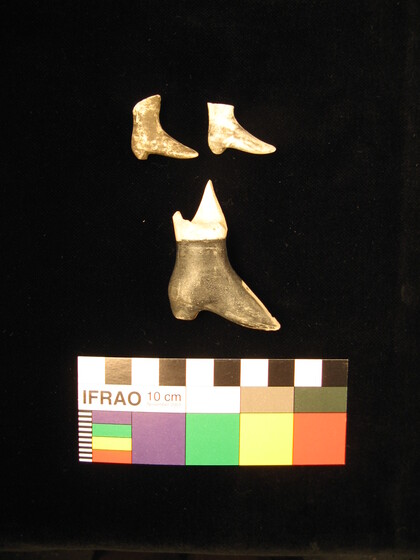 Three ceramic dolls shoes on a black background. A colour chart sits at the bottom of the image.