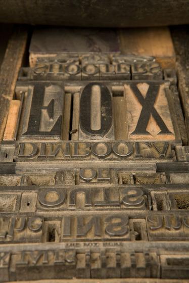 A wooden tray with a selection of loose type within it. 