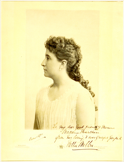 Sepia photograph of a profile portrait of a woman. She is wearing a cotton shirt or dress with exposed arms, hanging by her sides. Her hair is plaited and falls down her back.