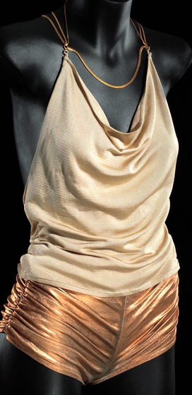 Mannequin wearing gold lame hotpants ruched at sides and a gold jersey top with gold chain neck and back straps