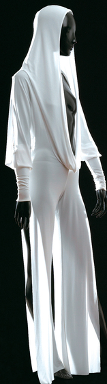 Mannequin wearing white jersey hooded jumpsuit with draped front opening and extended slits in pants and sleeves