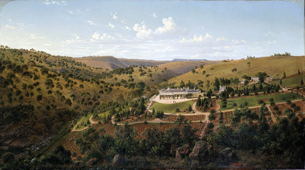 Painting of a large, grand homestead, positioned in a valley. The valley has mainly been cleared, but there are groups of trees and roads cut throughout the open space.