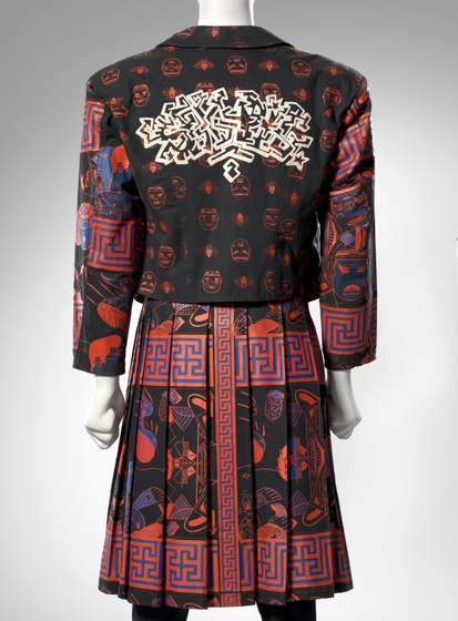 Mannequin dressed in a jacket and kilt, both emblazoned with bold colourful patters of red and blue.