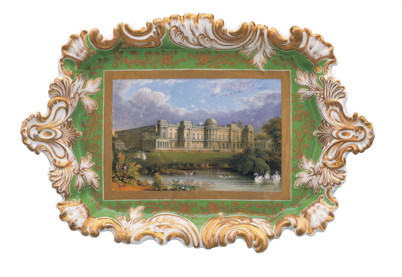 Decorative ceramic tray with green, white and gold patterning. At the base of the tray is a landscape painting of Buckingham Palace, framed by a lake with swans and ducks swimming within.
