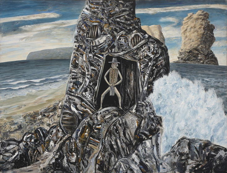 A man stands on a large rock, framed by an even larger rock behind him that includes a doorway type shape. Around the rocks splash large waves and the ocean. In the distance a more large rocks rising out of the ocean.