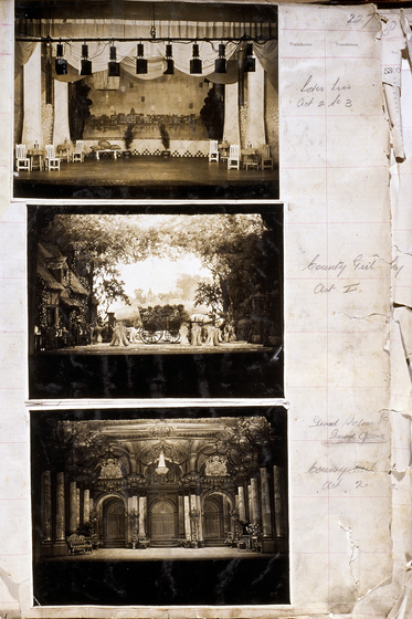 Three sepia photographs of different set designs, stuck to a scrapbook page. There are some hand written notes in the margin.