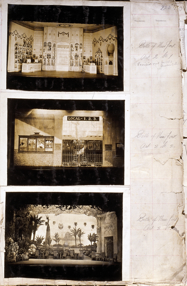 Three sepia photographs of different set designs, stuck to a scrapbook page. There are some hand written notes in the margin.