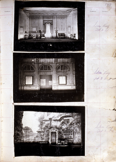 Three black and white photographs of different set designs, stuck to a scrapbook page. There are some hand written notes in the margin.