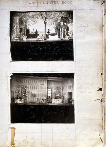 Two black and white photographs of different set designs, stuck to a scrapbook page. There are some hand written notes in the margin.