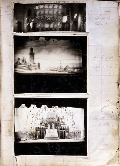 Three black and white photographs of different set designs, stuck to a scrapbook page. There are some hand written notes in the margin.