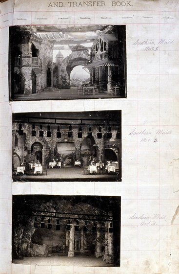 Three black and white photographs of different set designs, stuck to a scrapbook page. There are some hand written notes in the margin.