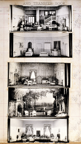 Five black and white photographs of different set designs, stuck to a scrapbook page. There are some hand written notes in the margin.