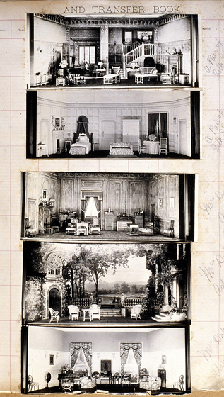 Five black and white photographs of different set designs, stuck to a scrapbook page. There are some hand written notes in the margin.