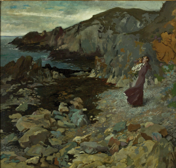 Two women stand on a rocky shoreline, looking out at the ocean. Behind them, larger rocks form the cliffs on the waters edge.