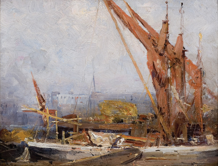 A barge boat floating next to the dock, a golden hay bale sitting on board.