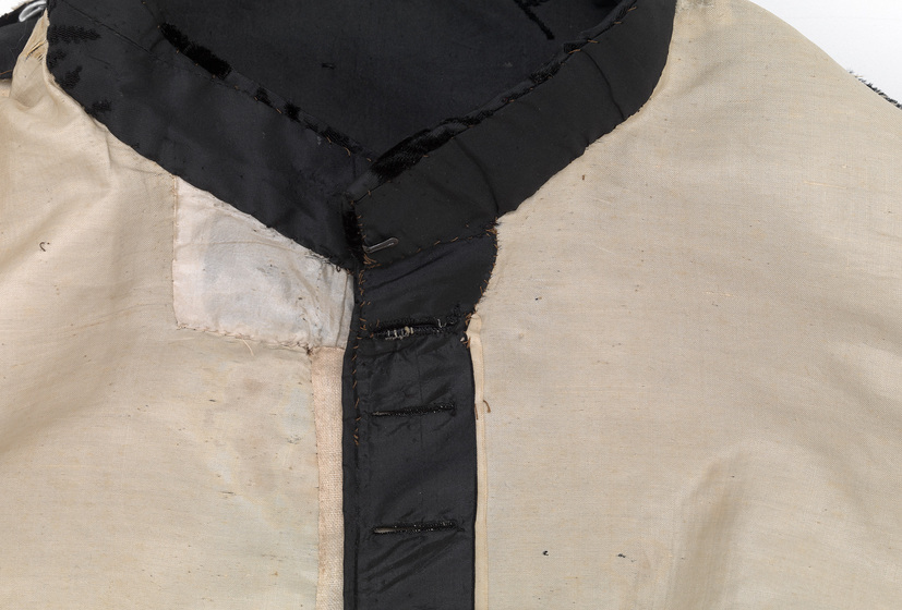 The inside of a piece of clothing, highlighting the neckline and front bodice lining in black