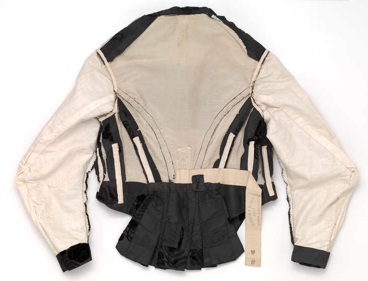 The inside of a bodice, featuring cream and black lining.