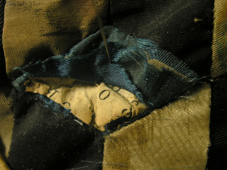 Detailed view of the inside of the dress, including stitched seams and parts of a label with lettering on it.