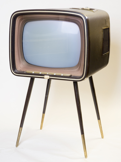 A bronze rounded square television set frame with four gold tipped legs.