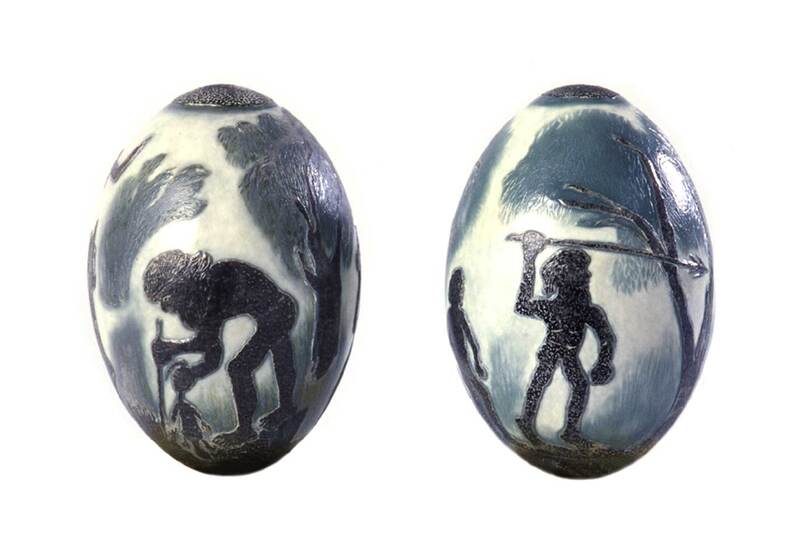 Two emu eggs, each painted with a scene of an indigenous person - one holding a spear in the air, one looking over the ground picking something up.