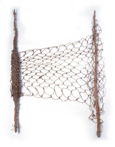 A piece of linked netting strecthed between two sticks, one side with part of the net coiled around it.