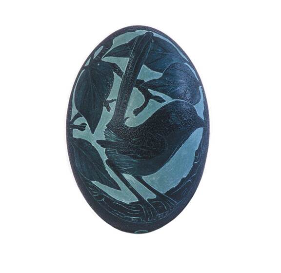A green emu egg with a blue wren painted on the side with a series of leaves around it.