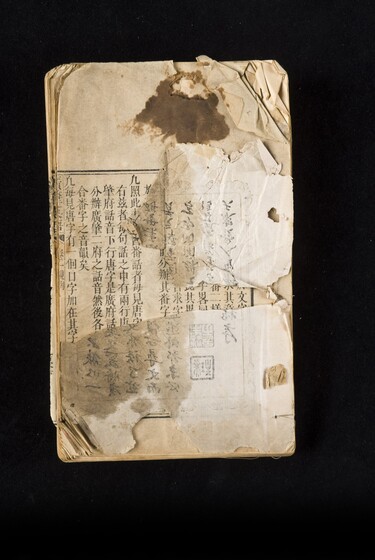 Single page book with Cantonese characters and slight damage to the paper, including staining and tearing.