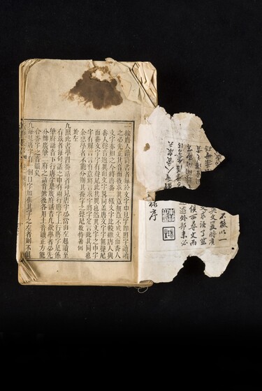 Single page book with Cantonese characters and slight damage to the paper, including staining and tearing.