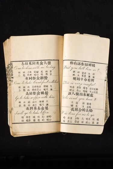 Double page book with Cantonese characters and English translations.