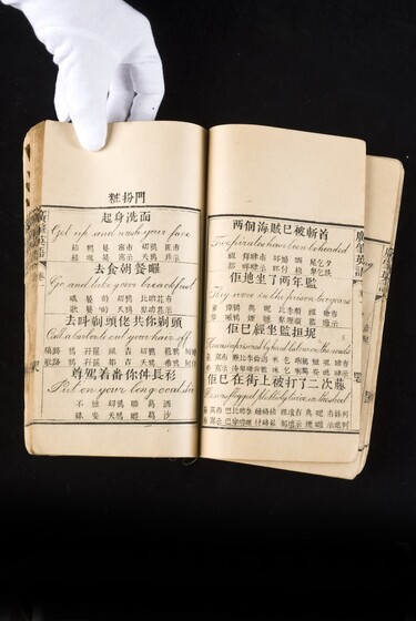 Double page book with Cantonese characters and English translations.