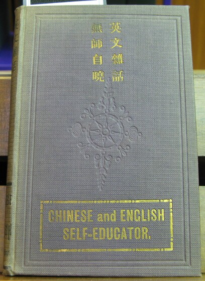 Front cover of a book in grey, with the book title in gold embossing, and a patterned imprint in the centre.