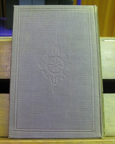 Back cover of a book in grey, with a patterned imprint in the centre.