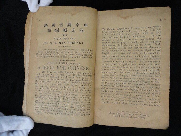 Double page book with some Cantonese characters on the top of the left hand page, and English wording for the remainder of the left and right hand pages.