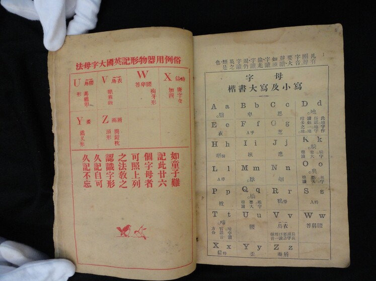 Double page book with Cantonese characters and English translations.
