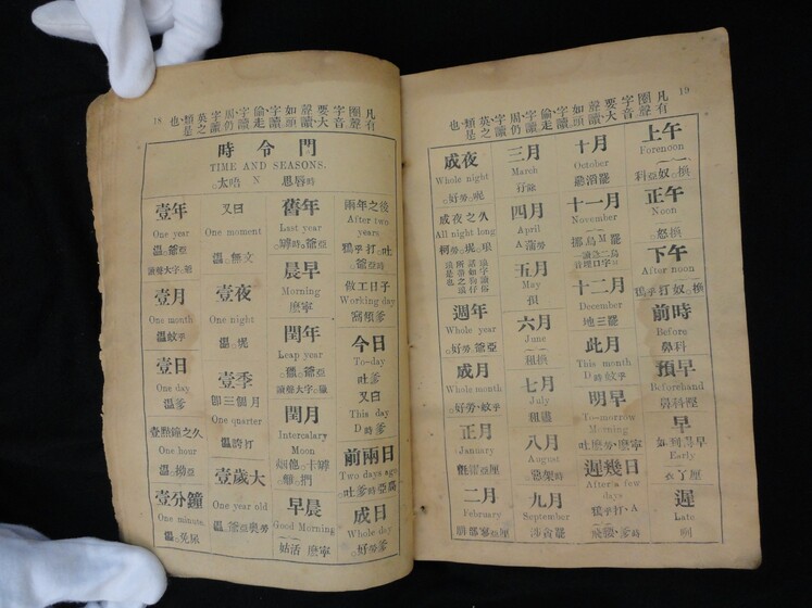 Double page book with Cantonese characters and English translations.