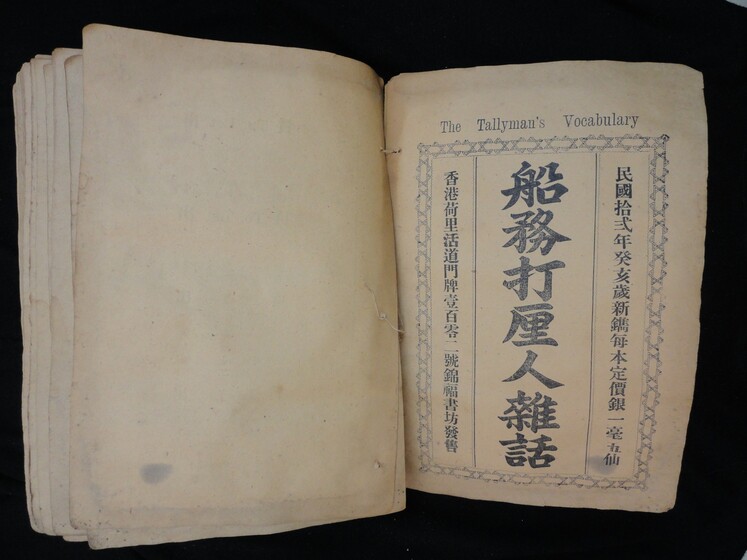 Double page book, blank on the left side and with Cantonese characters in black on the right hand side.