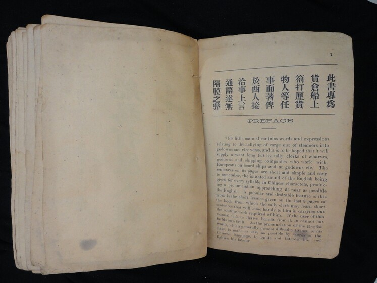Double page book, blank on the left hand side and English and Cantonese writing on the right hand side.