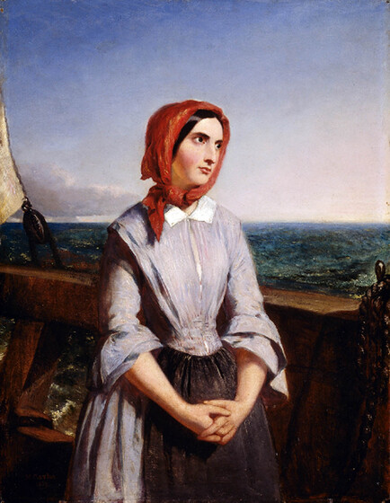 A woman stands on the bough of a boat, her hands clasped in front of her whilst she looks out towards the ocean. She is wearing a bright red bonnet, a blue dress and an apron wrapped around her waist.
