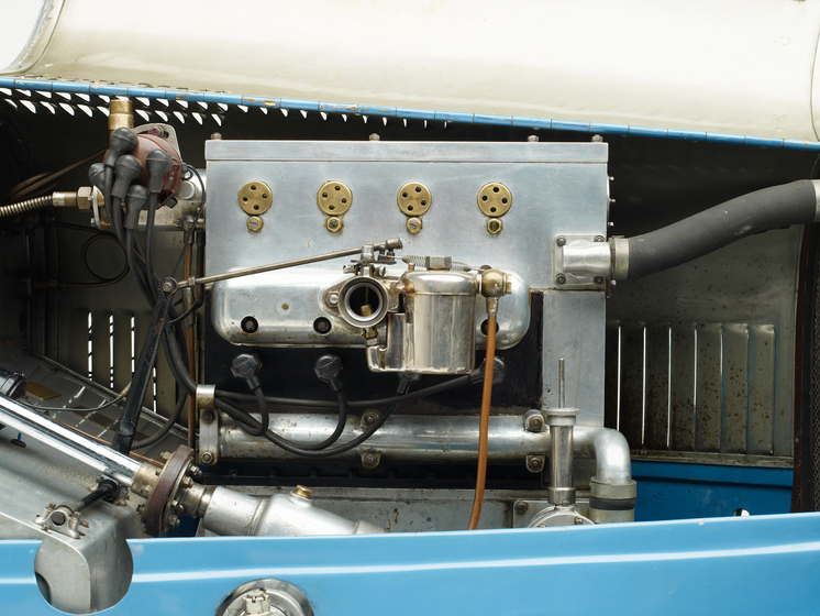 A zoomed in view of the cars motor with slight parts of the bonnet, indicating the motor is inside the car.
