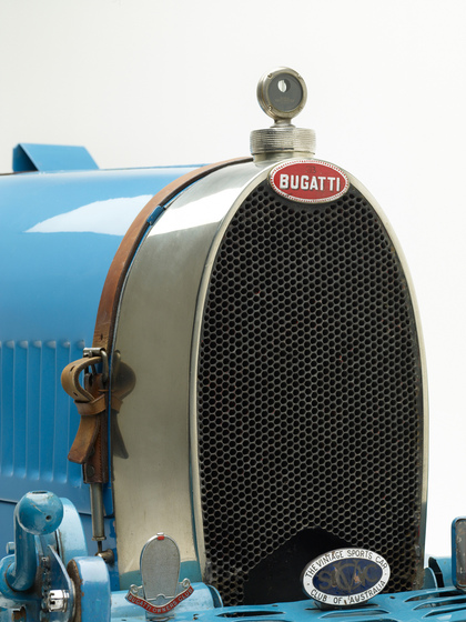 A close up view of the front of the car, specially the grate and the name plates that read 'Bugatti' and 'The Vintage Sports Car Club of Australia'.