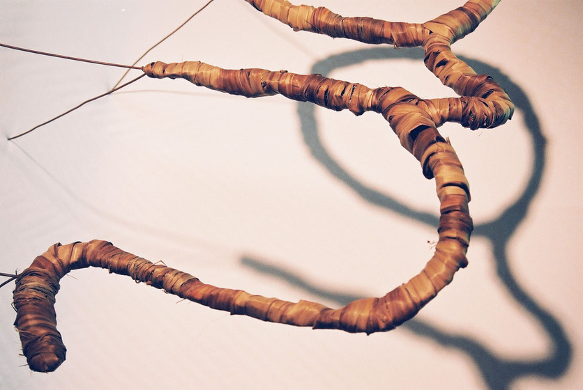 Curved wire wrapped in a type of rattan, reflecting the look of a tree branch.
