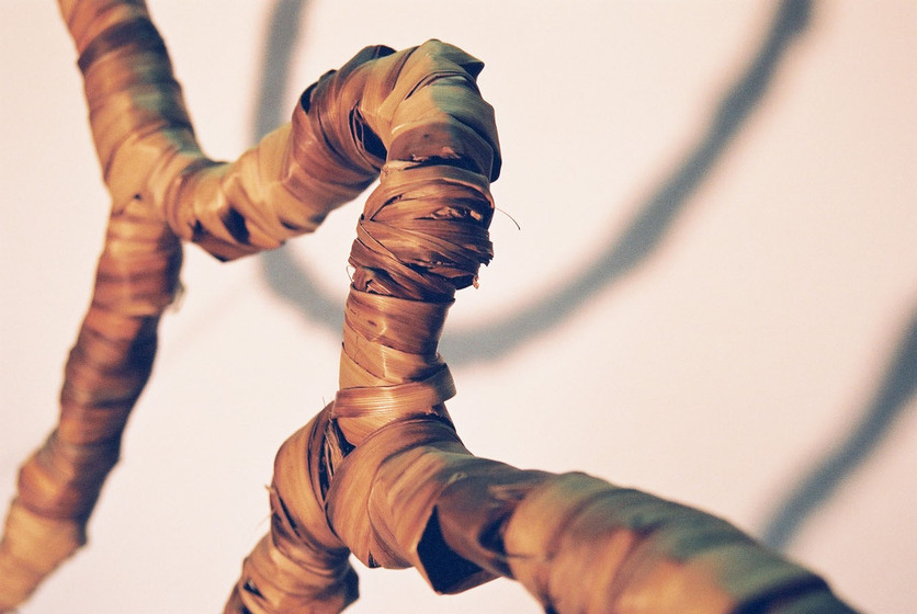 Curved wire wrapped in a type of rattan, reflecting the look of a tree branch.