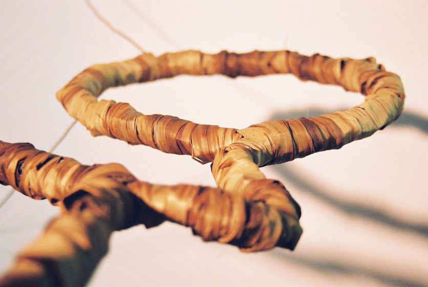 Curved wire wrapped in a type of rattan, reflecting the look of a tree branch.