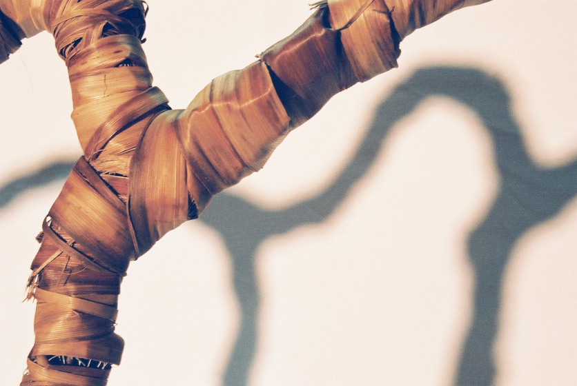Curved wire wrapped in a type of rattan, reflecting the look of a tree branch.