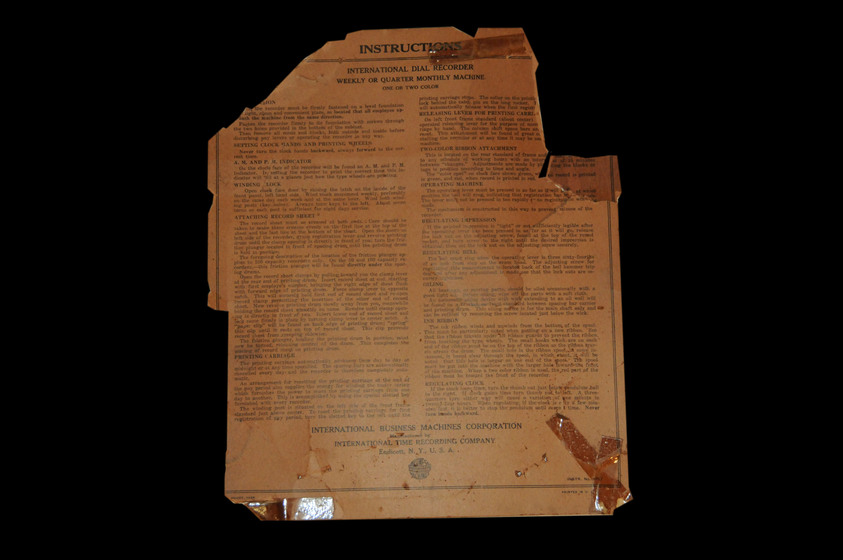 A typed out instruction manual on browning paper, with rips off both top corners and staining across the top right corner.