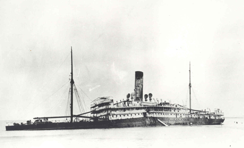Photograph of a long steamboat tilting slightly to the side in the water.