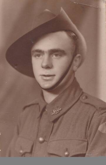 Studio torso portrait of a young man in military uniform wearing an Australian slouch hat.