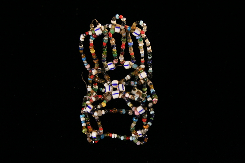 Front view of a amall chair made from white multi-coloured small beads.