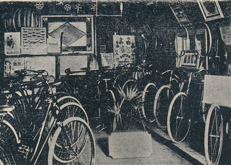 Small room with rows of standing up bicycles. Posters cover the walls.