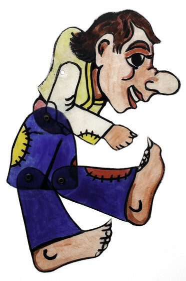 Acrylic figure of a man, jointed with pins at the waist and knees. He has an exaggerated face with large nose and large oversized feet. He wears blue trousers with red and yellow patches, and a yellow vest. He is positioned running tilted forward with one leg raised. 